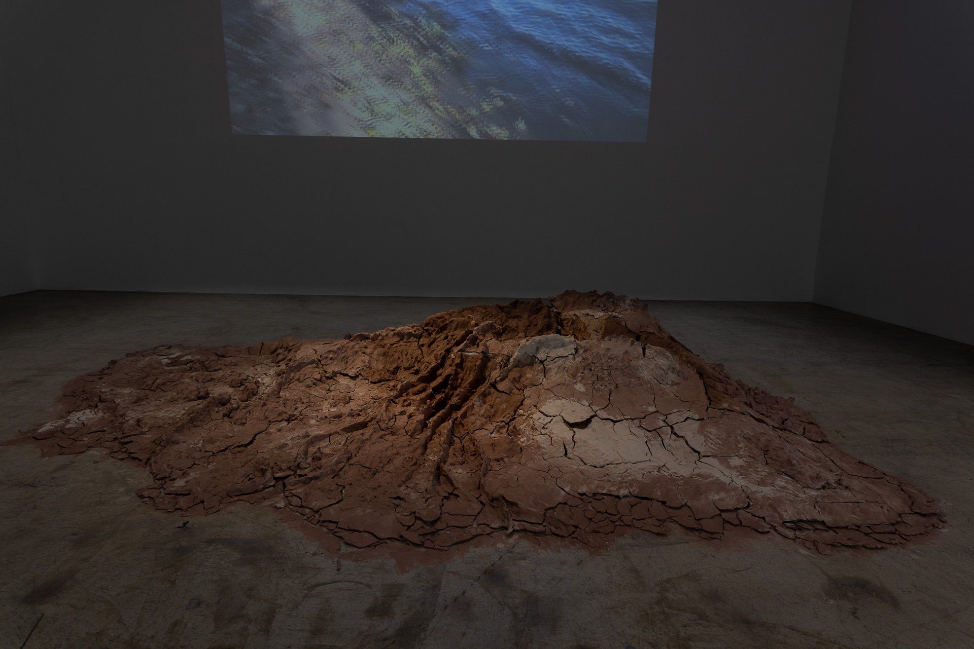 A large pile of dirt is sitting on the floor in a dark room.