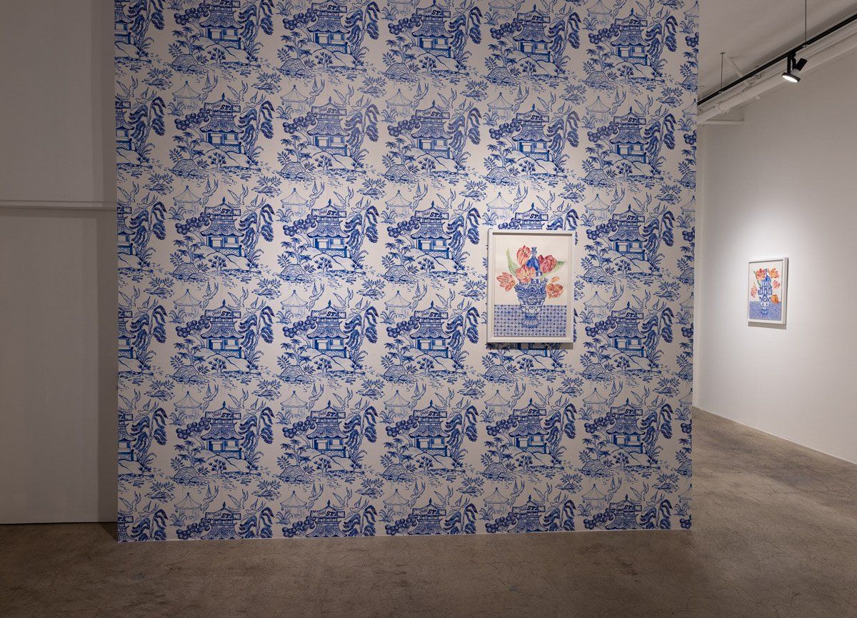 A wall with a blue and white pattern on it and a painting on it.