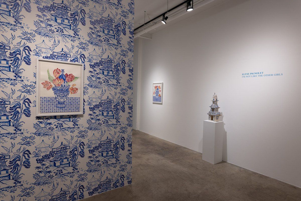 A hallway with blue and white wallpaper and a painting on the wall.