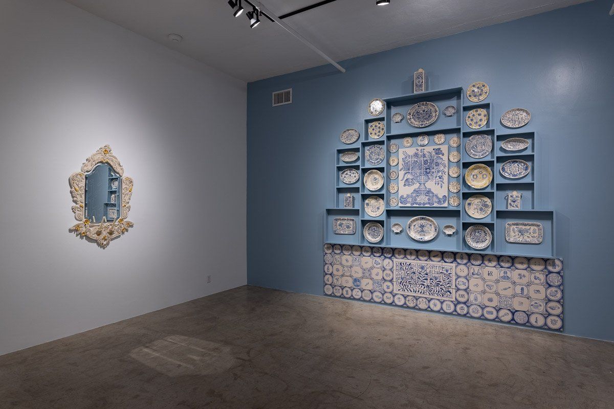 A room with a lot of plates on the wall and a mirror on the wall.