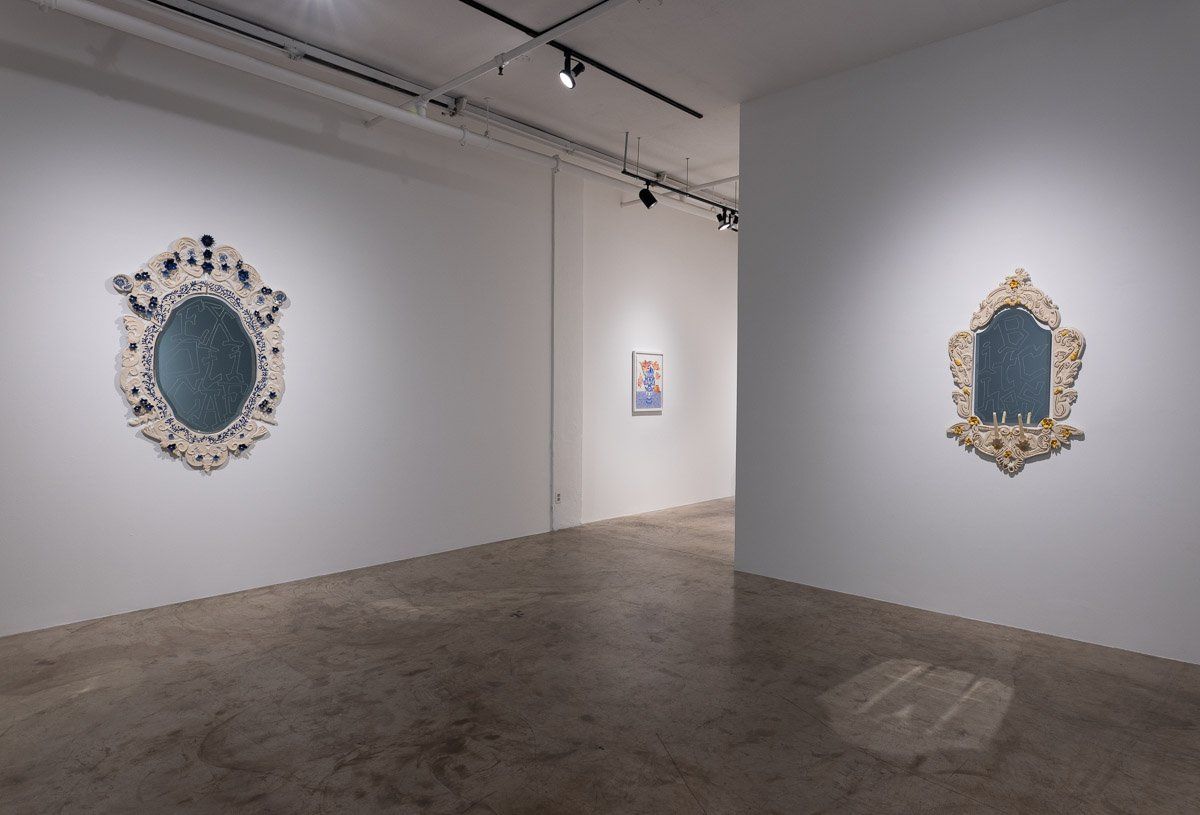 There are two mirrors on the wall in a room.
