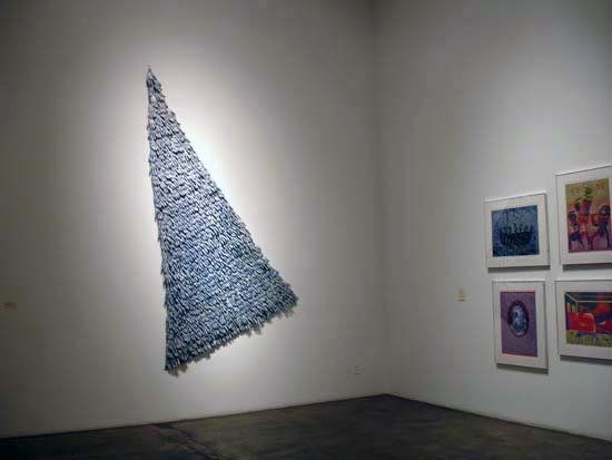 A room with a triangle shaped sculpture on the wall.