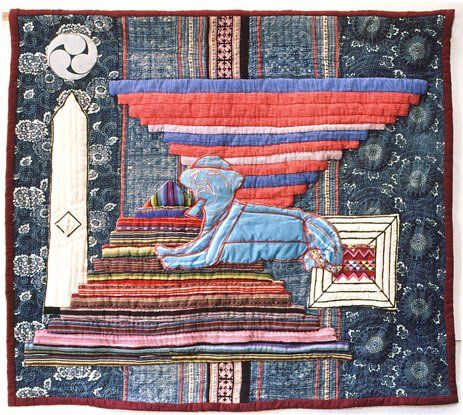 A quilt with a pyramid in the middle of it
