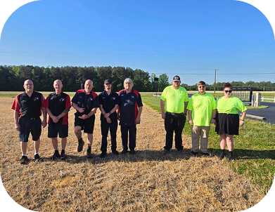 Soccer team lineup on a field, players in black and neon green uniforms standing in a row outdoors | Dewitt's Automotive Center