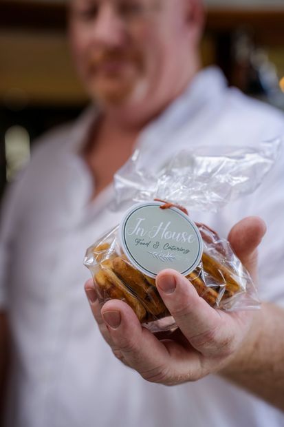 A man is holding a bag of cookies in his hand.