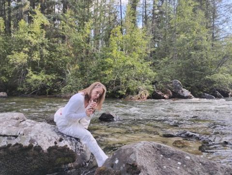 Woman in white sitting on rocks