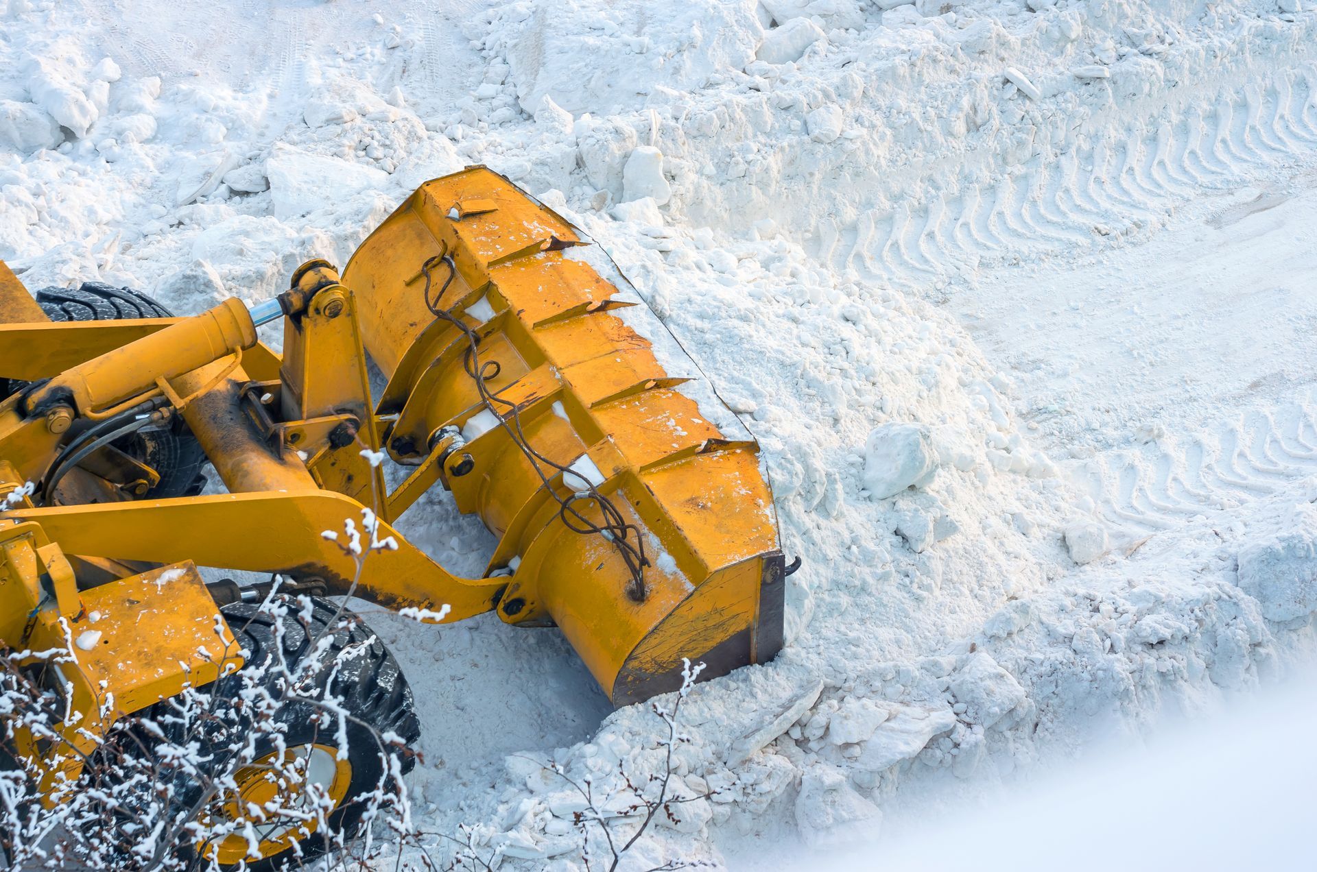 Yellow snowplow clearing snow.