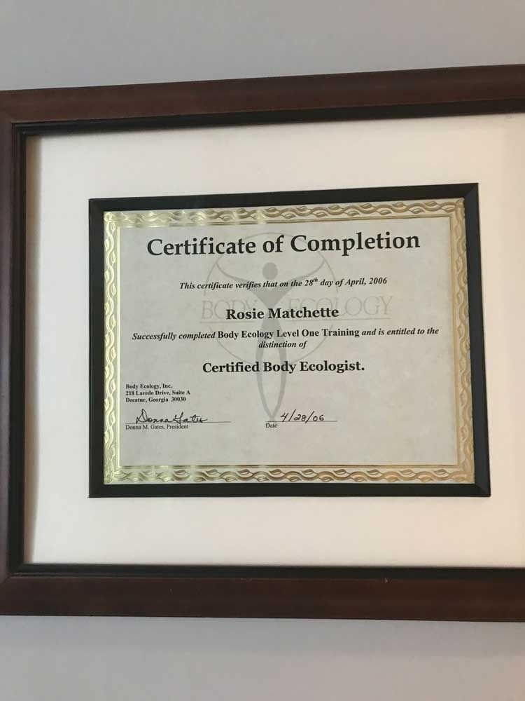 Framed certificate of completion with beige paper and black mat on a white wall