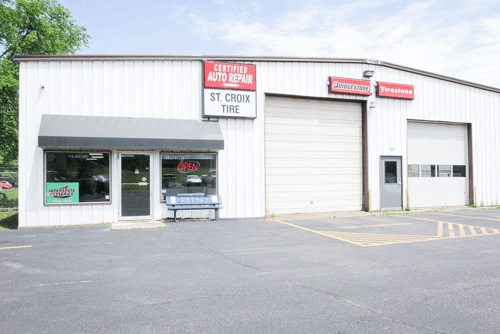 St. Croix Falls Tire & Auto building with garage bays, storefront windows, and a parking lot