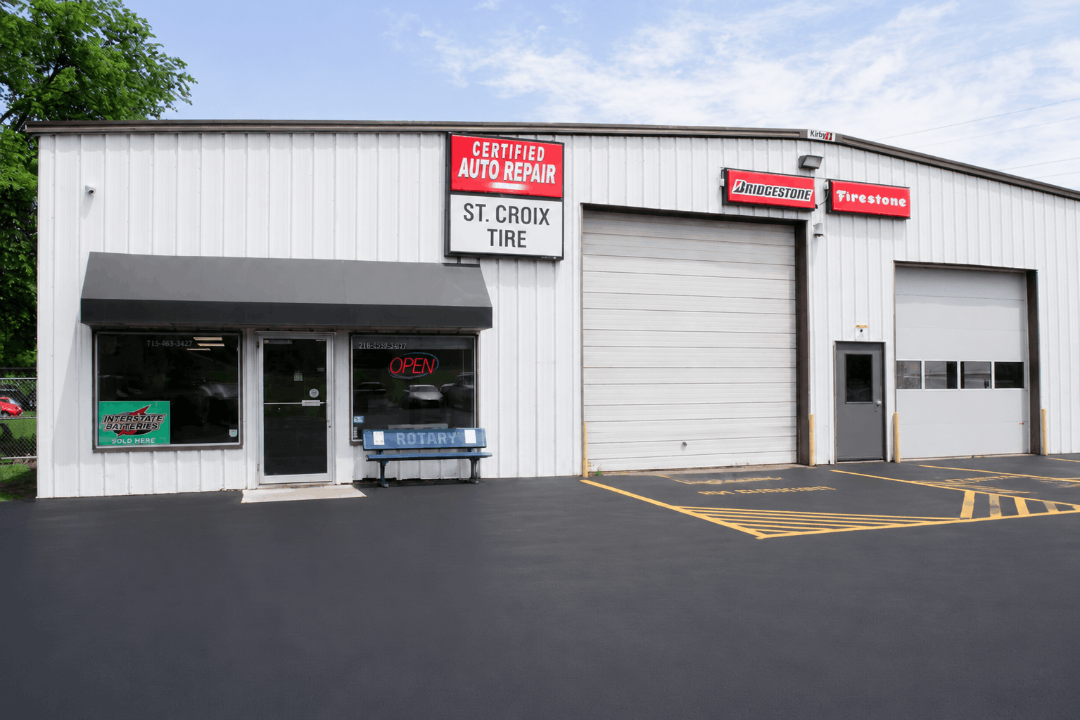 St. Croix Falls Tire & Auto building with garage bays, storefront windows, and a parking lot