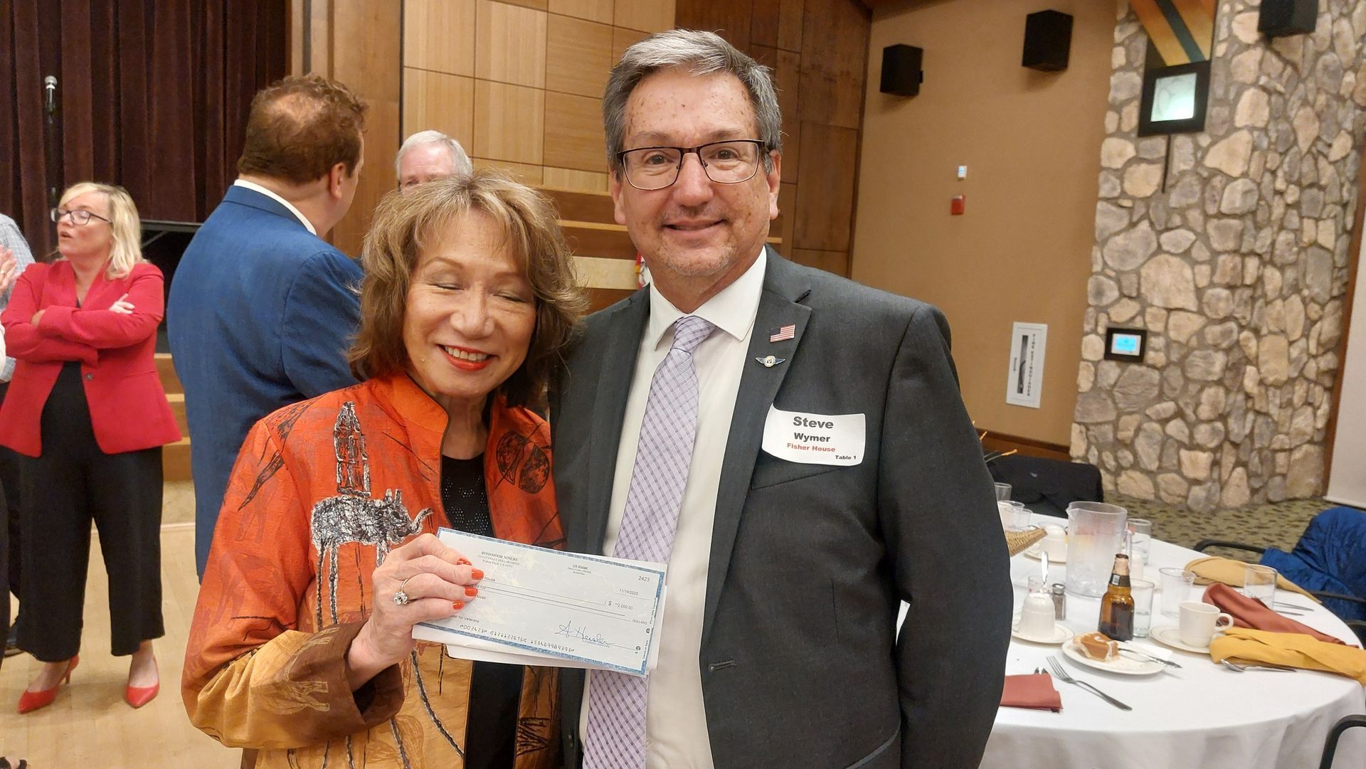 Woman and man posing with a certificate at a formal indoor event