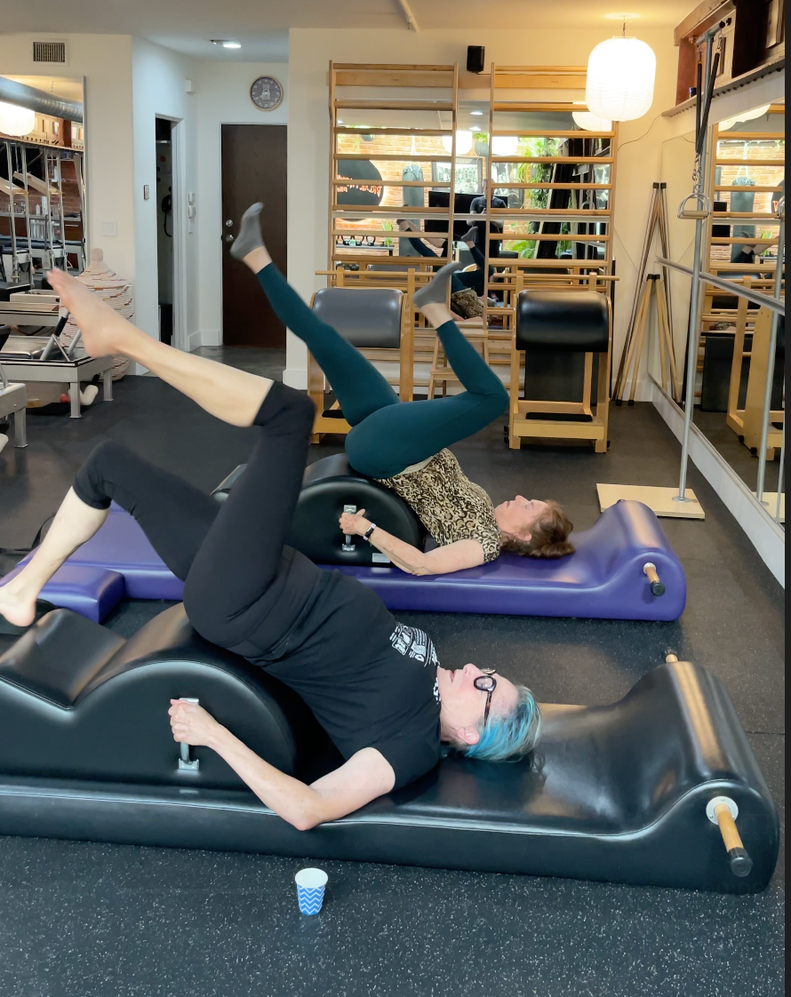 Classical Pilates instructor guiding seniors through Spine Corrector exercises to improve posture