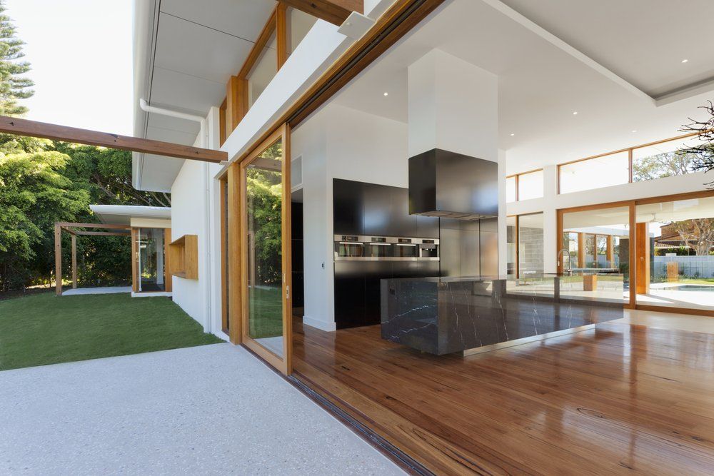 Spacious kitchen with black countertops and cabinets — New Homes in Wamberal, NSW