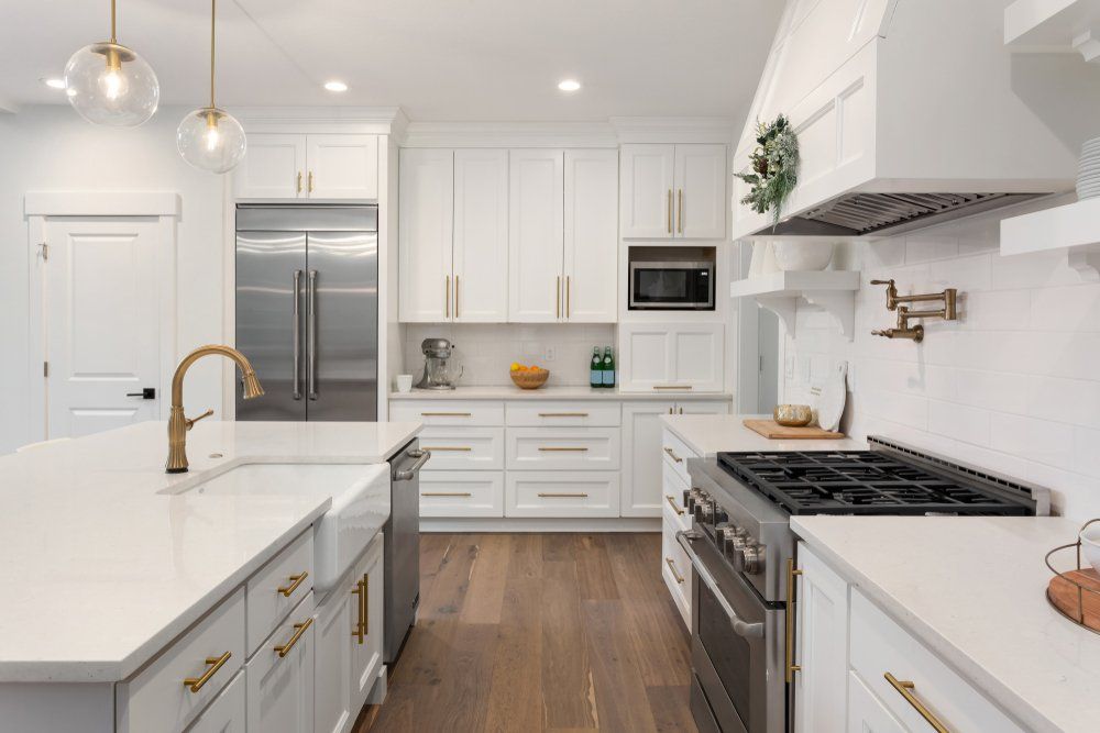 Kitchen with white cabinets and wooden floor — New Homes in Wamberal, NSW