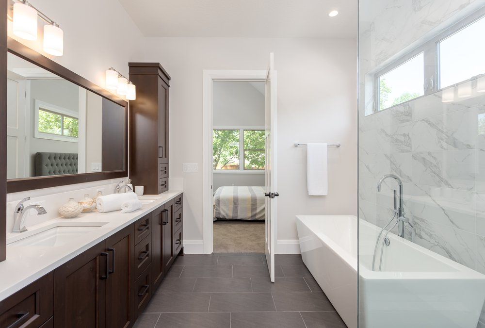 Master bathroom with dark wood cabinetry — New Homes in Wamberal, NSW