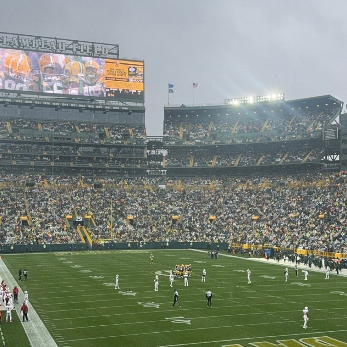 Football game in a packed stadium with players on the field under cloudy skies