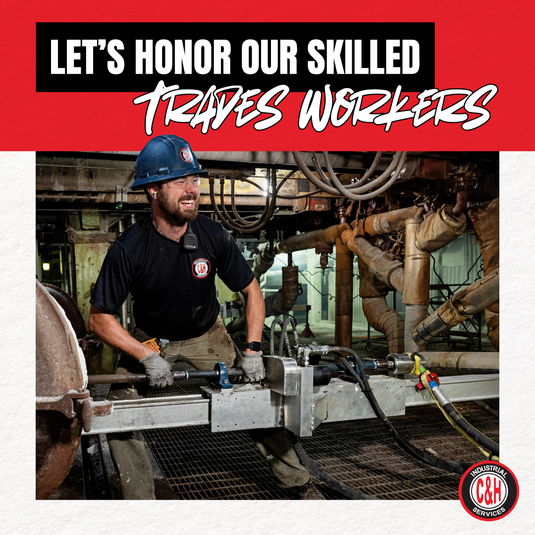 Worker in a blue hard hat using a tool in an industrial setting under a “Let’s honor our skilled trades workers” banner