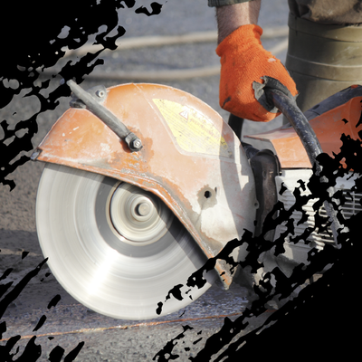 Worker using an orange-gloved hand to cut pavement with a circular concrete saw