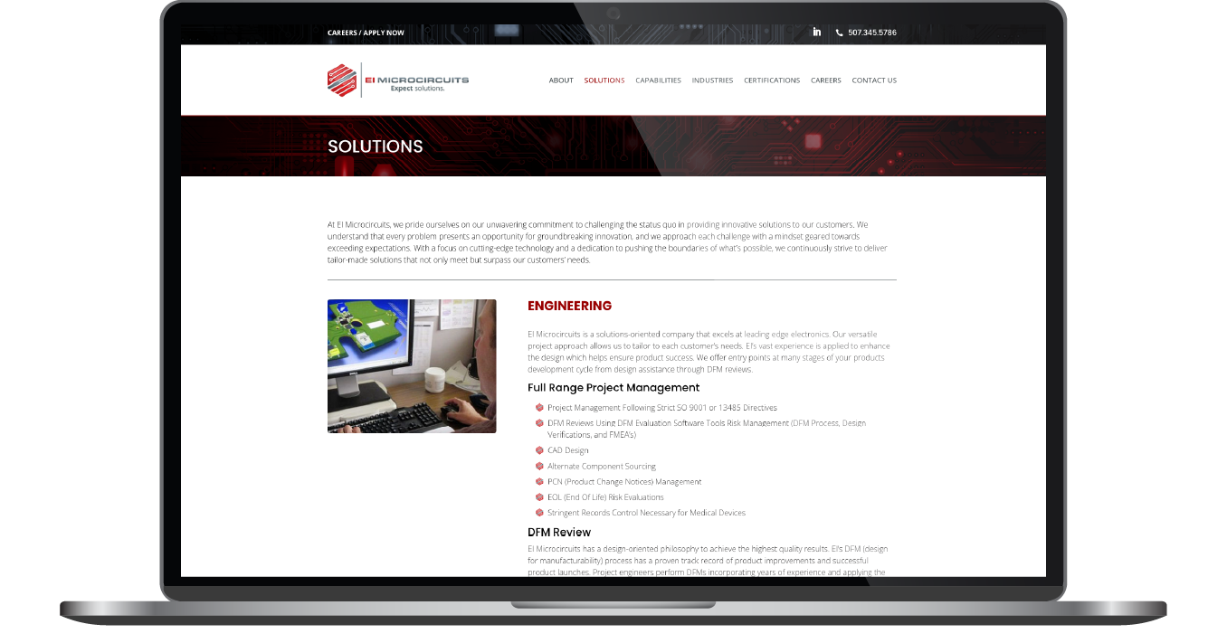 Laptop displaying a website page with a computer monitor and keyboard setup image