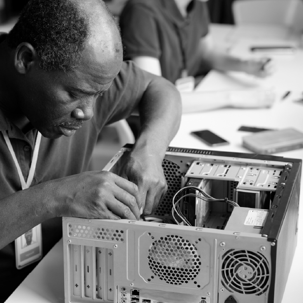 Technician repairing the inside of a desktop computer on a workbench