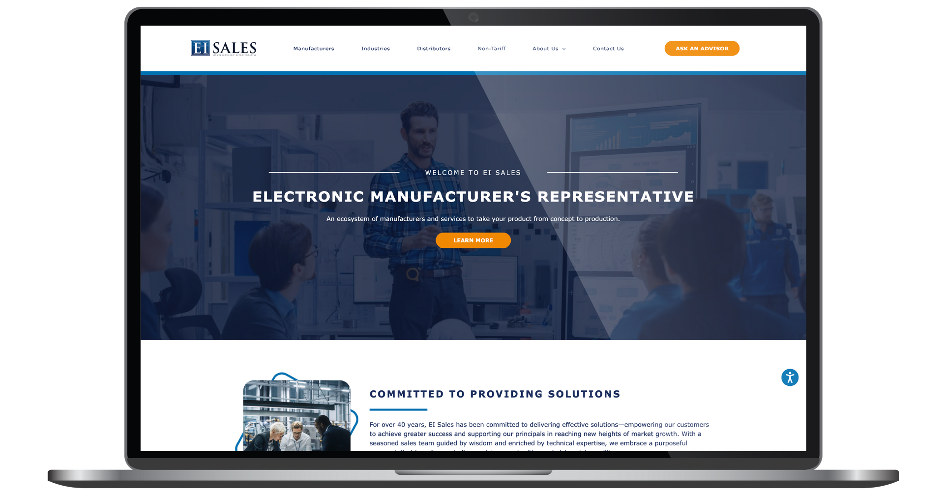 Laptop displaying a corporate website homepage with a blue hero banner and orange call-to-action button