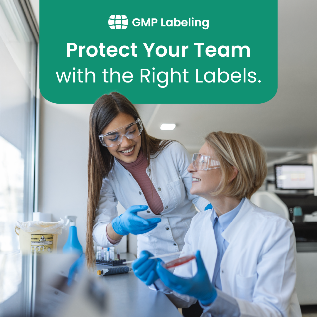 Two lab workers in blue gloves discussing labels in a bright GMP lab, with “Protect Your Team” text.