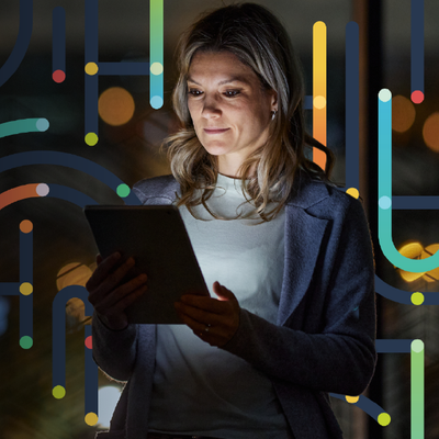 Woman holding a tablet in a dark room with colorful glowing abstract lines in the background