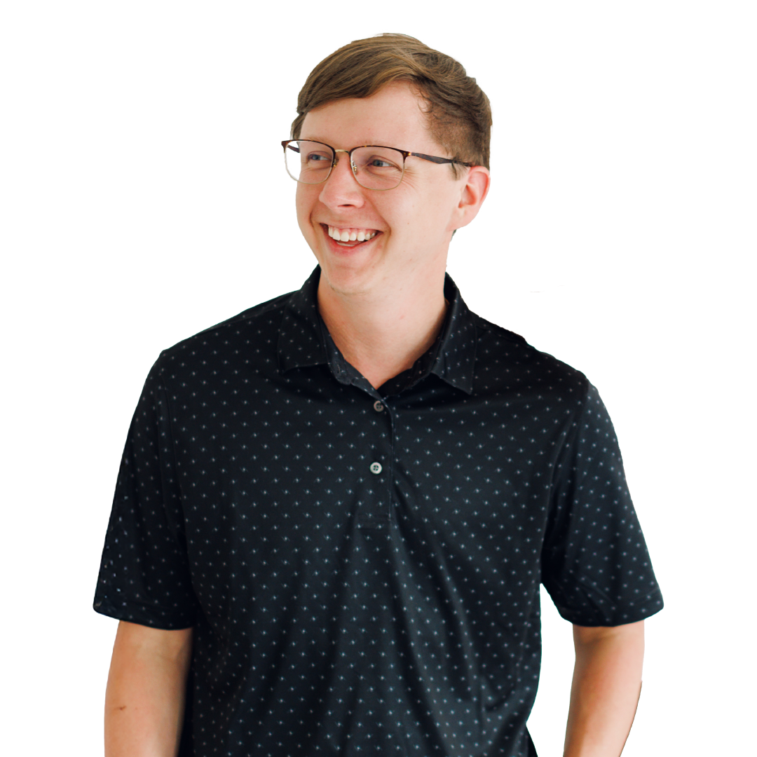 Smiling person in glasses wearing a dark patterned polo shirt against a white background
