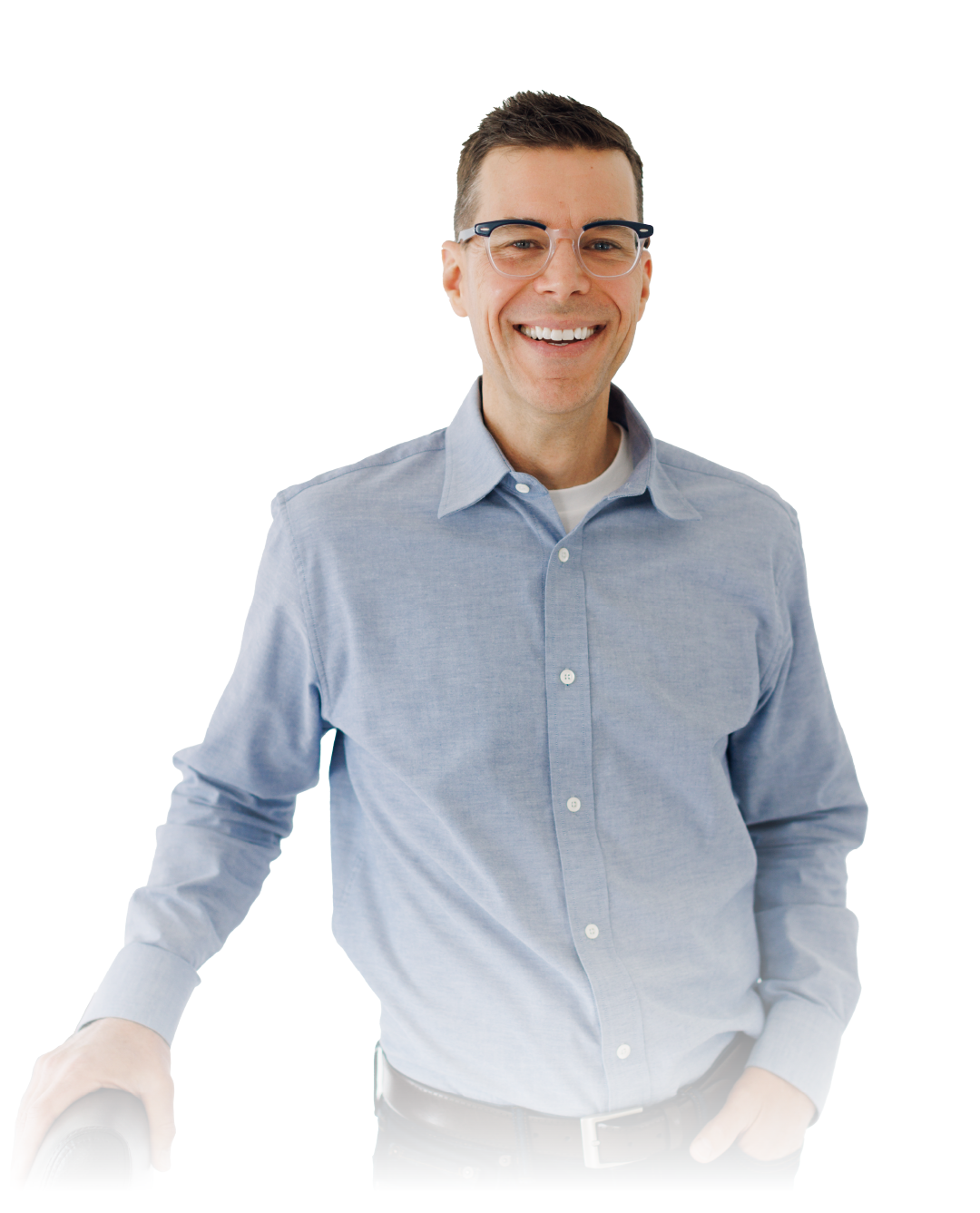 Smiling person in a light blue shirt and glasses standing against a white background