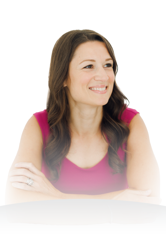 Smiling woman in a pink top with arms crossed against a white background