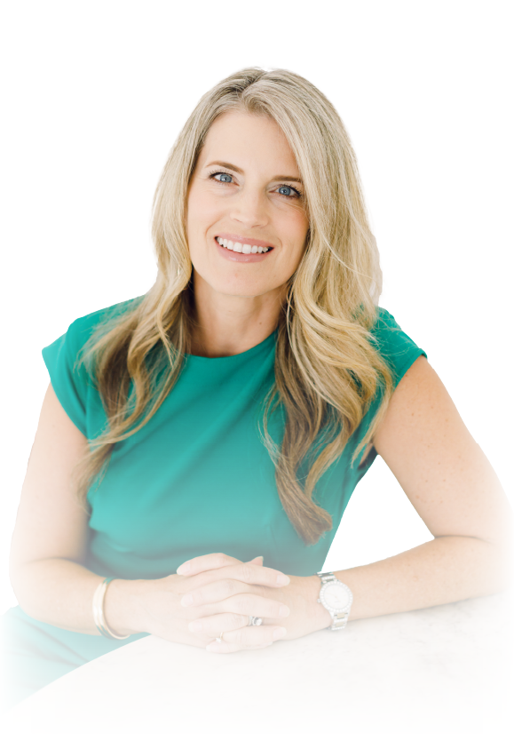 Smiling woman in a teal blouse with blonde hair, seated against a white background.