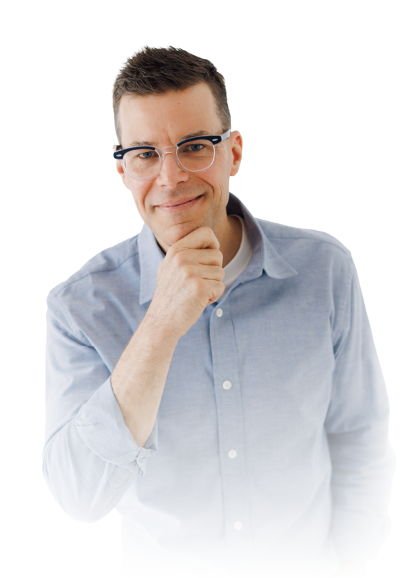 Man in glasses and light blue shirt smiling with hand on chin against a white background