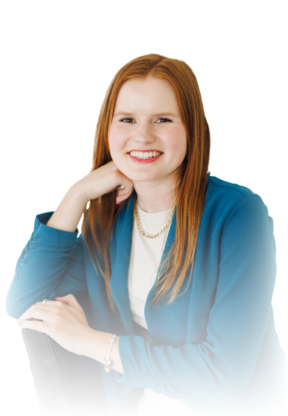 Smiling person with red hair in a blue blazer, resting chin on hand against a white background