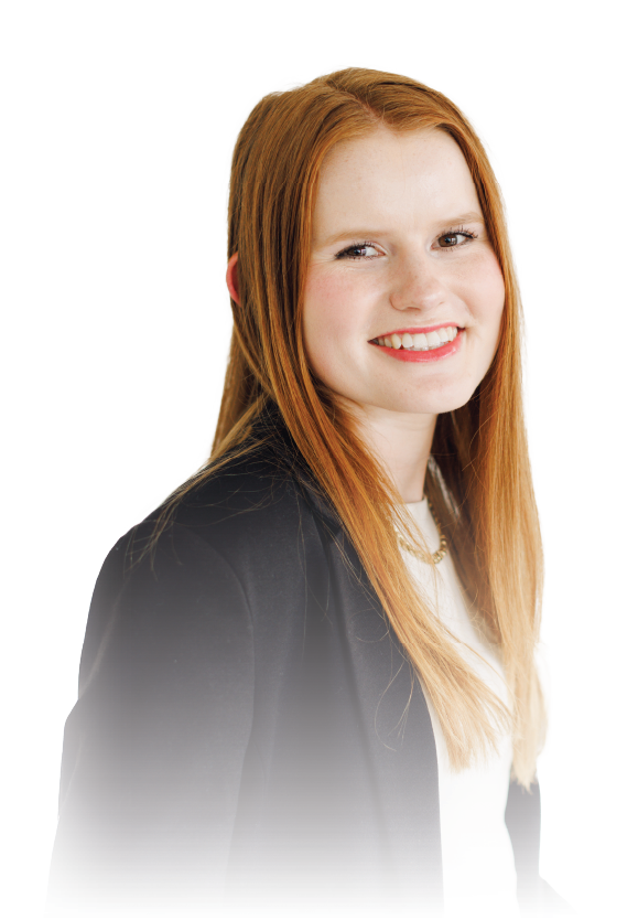 Smiling red-haired woman in a black blazer against a white background