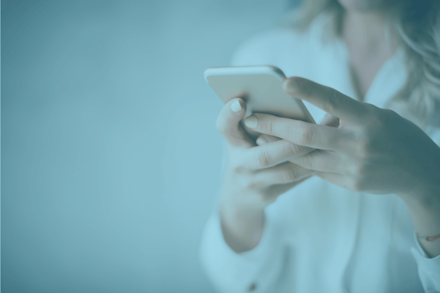 Person holding a smartphone in a softly lit blue setting