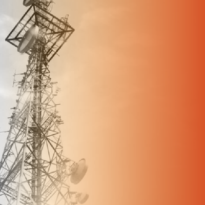 Communication tower with dishes against a hazy orange sky
