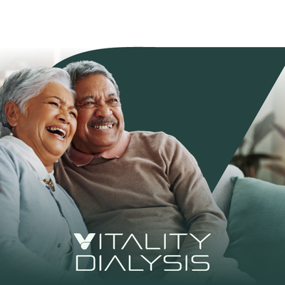 Smiling seniors on a couch beside the Vitality Dialysis logo on a teal background