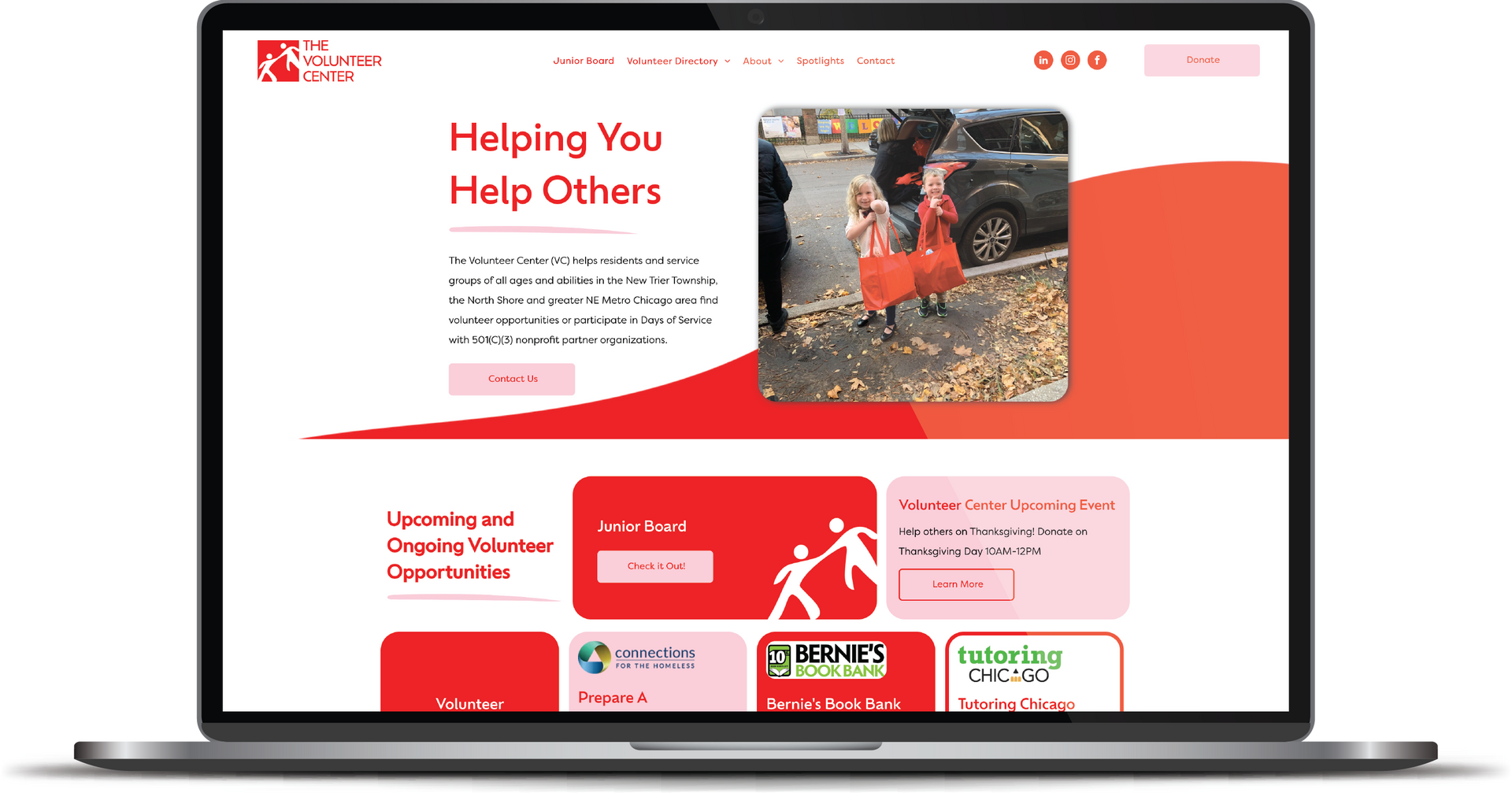 Laptop displaying a red-and-white charity website with a rescue photo and “Helping You Help Others” headline