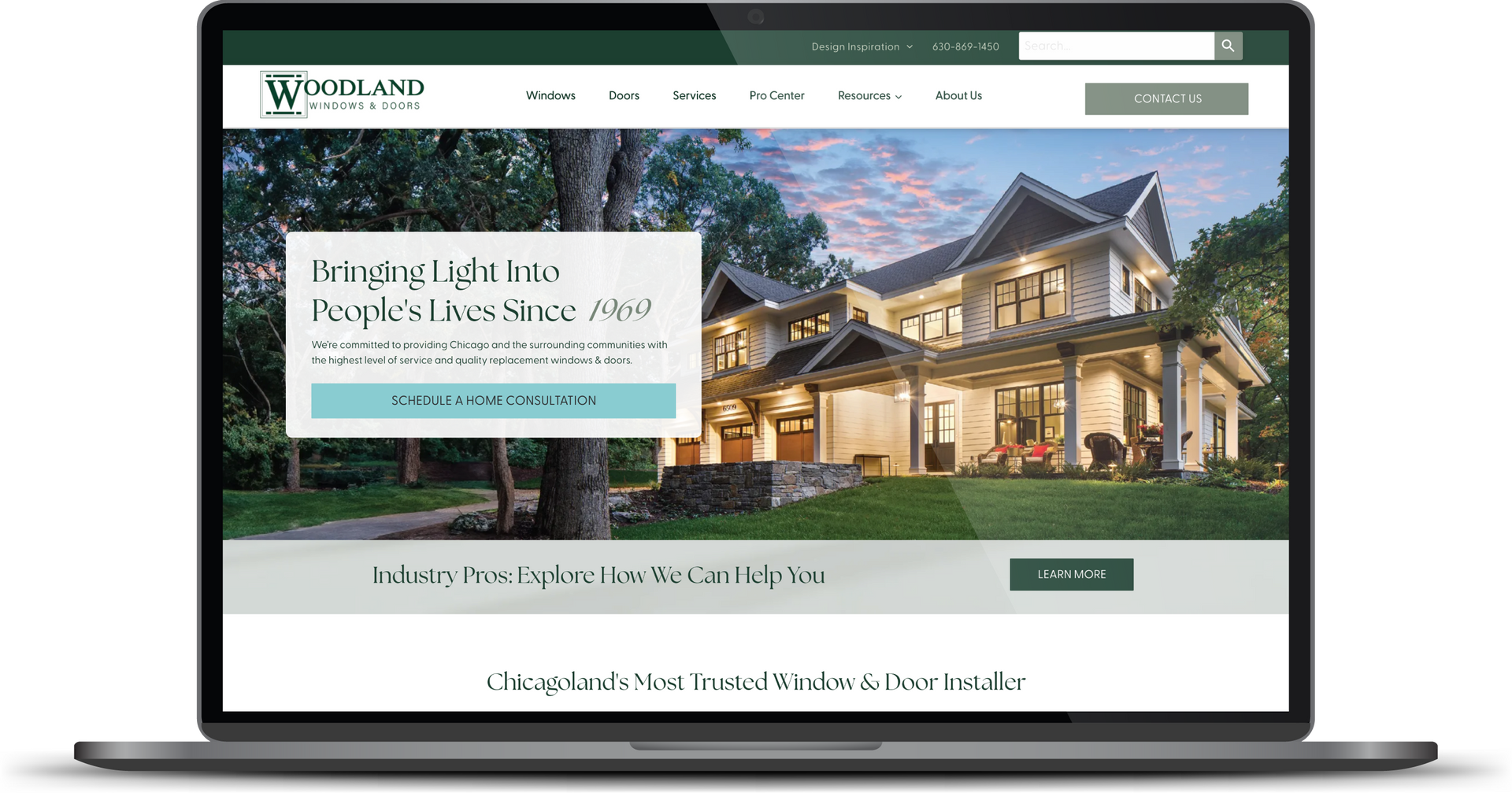 Laptop displaying a real estate website with a large house photo and search bar