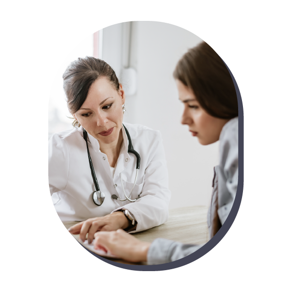Doctor consulting a patient in a bright clinic, pointing at notes on a desk.