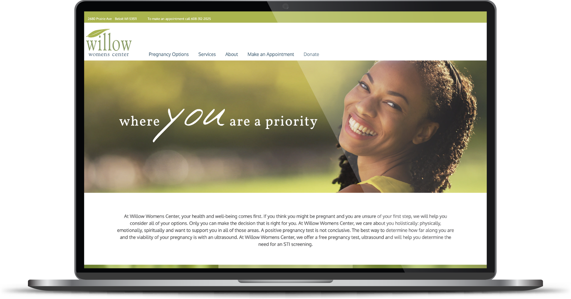 Laptop displaying a website with a smiling woman in a green header banner