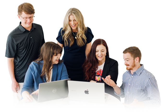 Five coworkers gathered around laptops, looking at a screen and collaborating in a bright office.