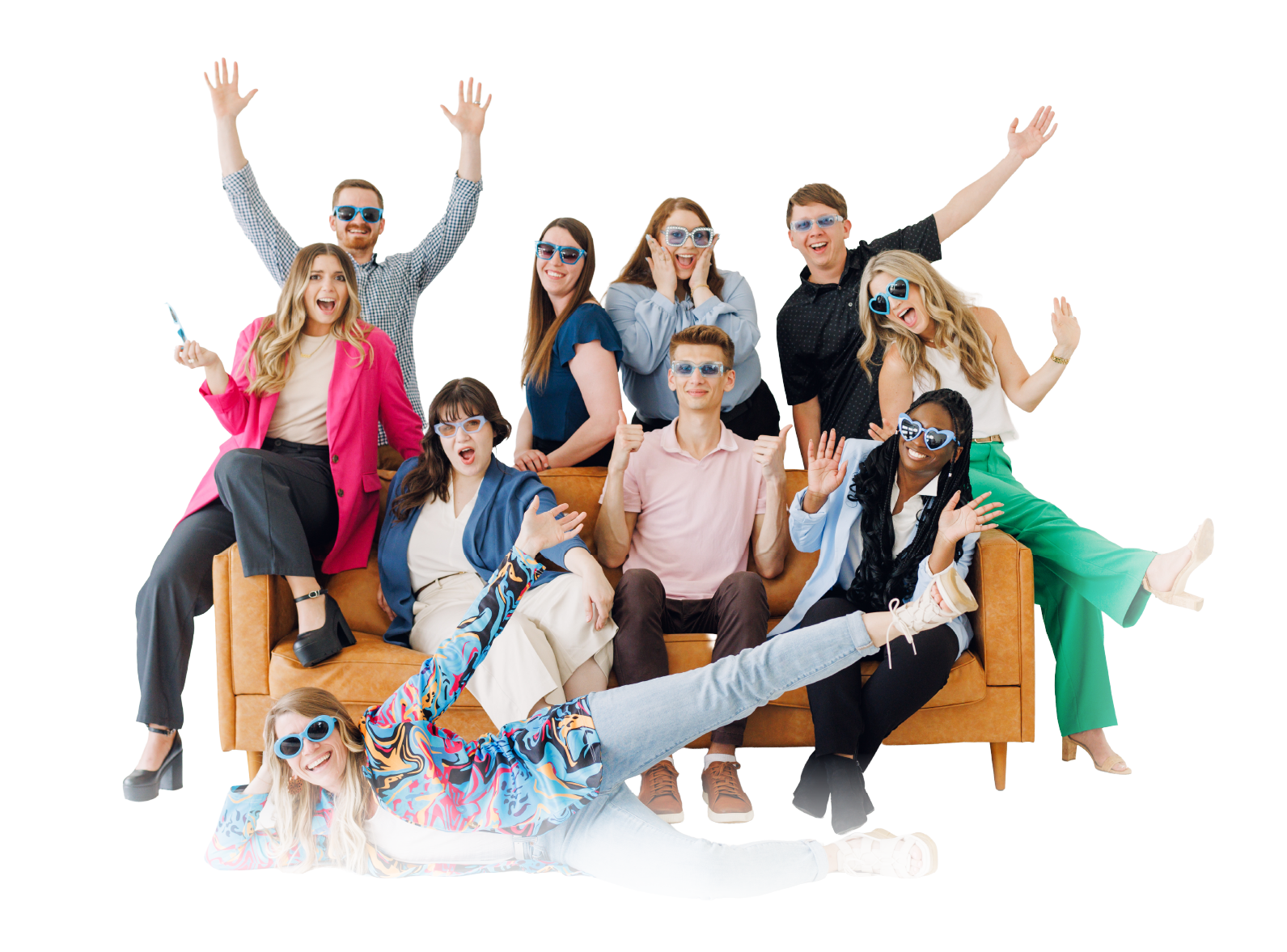 Group of people posing playfully on and around a brown couch against a white background