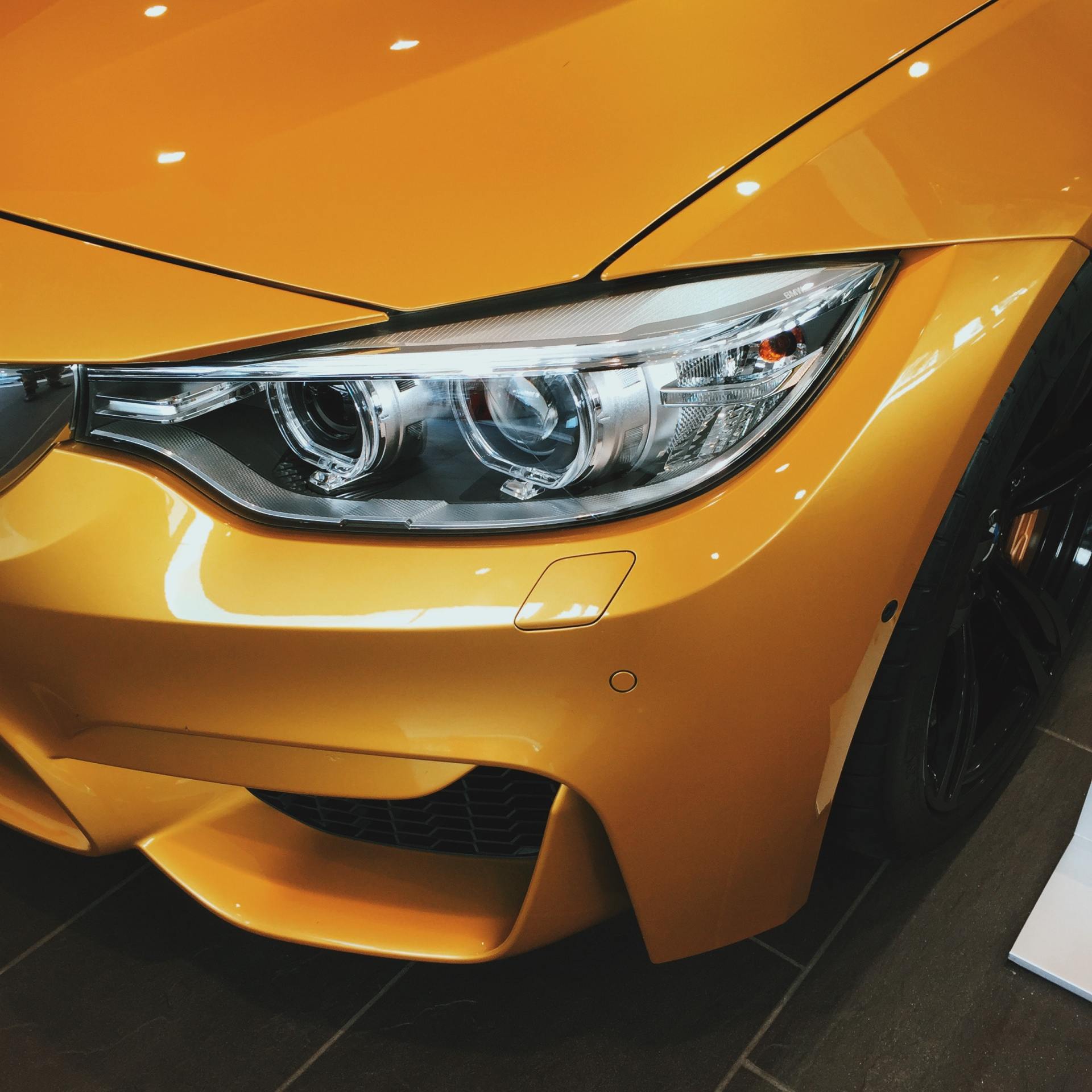 A close up of the front of a yellow car