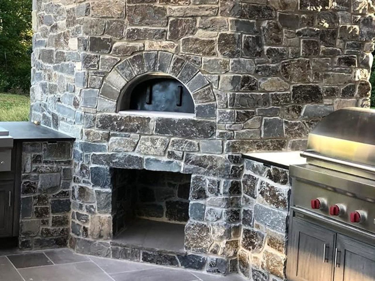 Natural Stone Outdoor Kitchen with a built in wood burning stove and fireplace in maryland