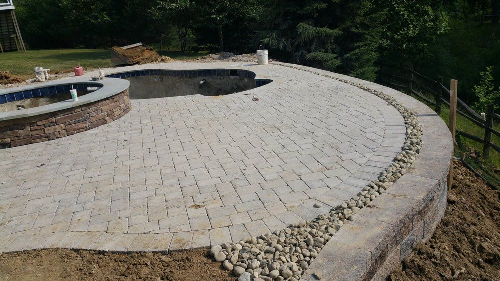 Custom patio with built-in fire pit and retaining wall under construction by J Gonzalez Construction, showcasing expert hardscaping design and craftsmanship.