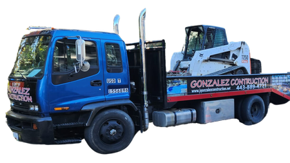 A blue tow truck with a bulldozer on the back of it.