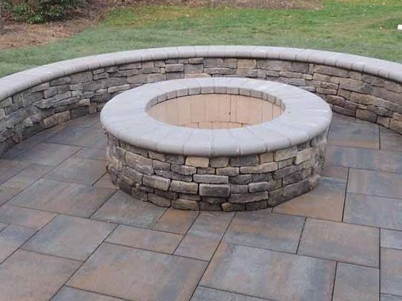 A fire pit is surrounded by a stone wall on a patio installed by J Gonzalez Construction in Maryland