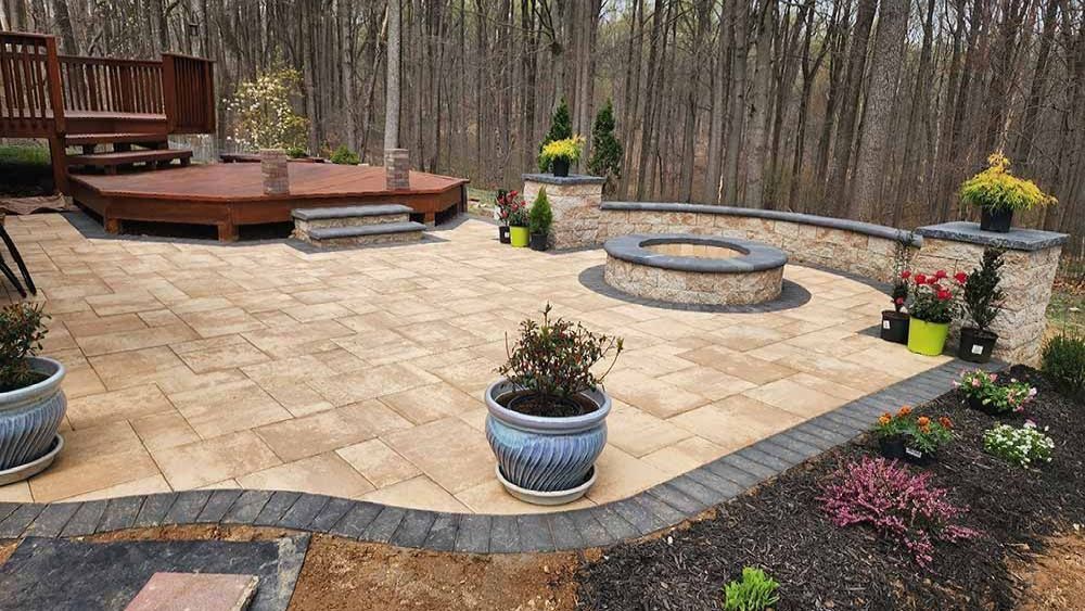 Functional patio designed and installed by J Gonzalez in Maryland, with deck, fire pit and seating wall