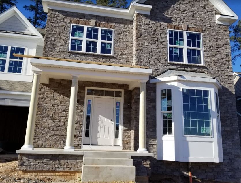 A brick house with white windows and a porch